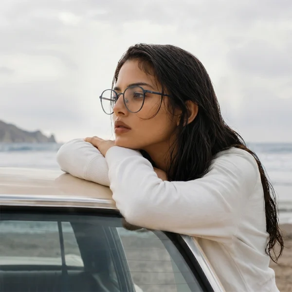 Woman wearing blue Selen Eyewear glasses by the sea