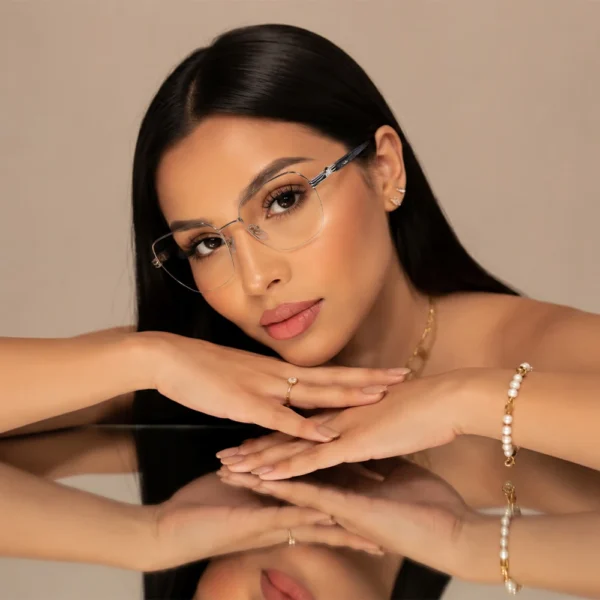 Woman wearing Selen Eyewear full-rim metal optical glasses with a reflective tabletop portrait.