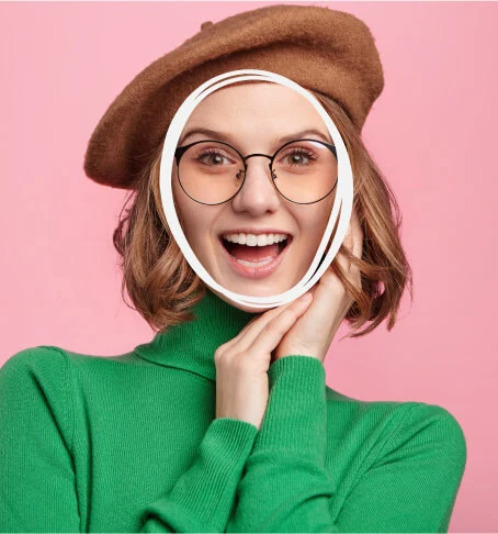 Smiling woman wearing black Selen Eyewear glasses in a playful pink portrait